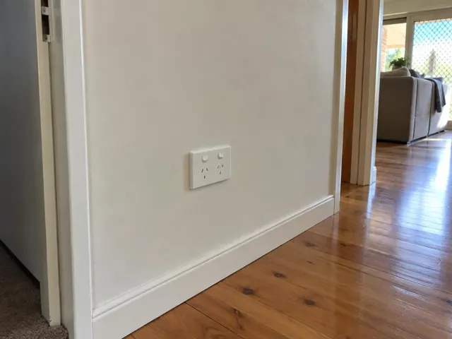Double power point on a white interior wall above timber flooring in Cameron Park
